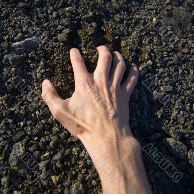 Hand clinging stony ground