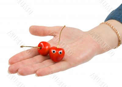 Two sweet cherries on palm