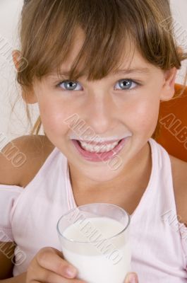 smiling girl with glass of milk looking