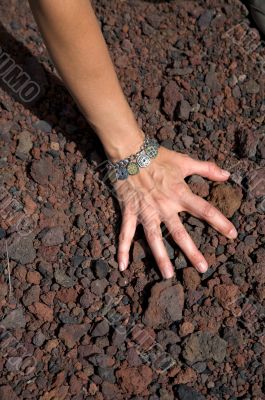 hand on volcanic stones