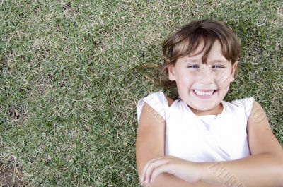 young cute girl lying on the grass