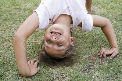 girl doing cartwheel in the grass
