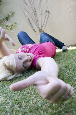 american blonde female lying on grass