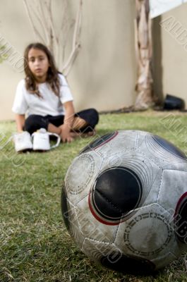 close up of football and boy sitting on background