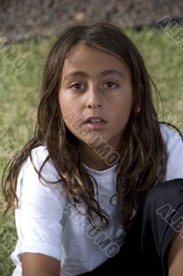 adorable young boy sitting on green grass