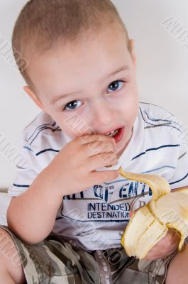 cute boy holding peeled banana