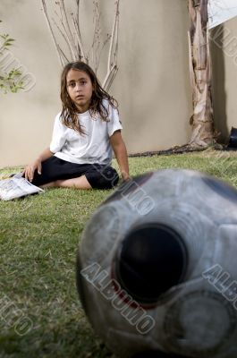 tired boy sitting near soccer ball