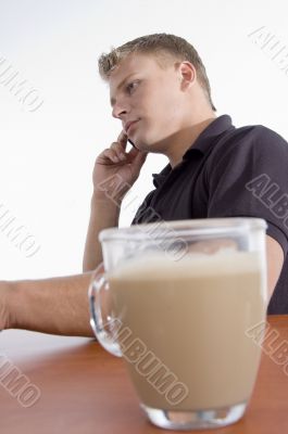 man busy on cell phone with tea cup