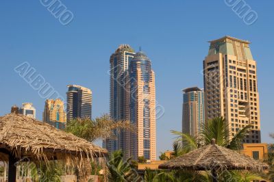 Palm trees, beach umbrellas and skyscrapers Palm trees, beach umbrellas and skyscrapers