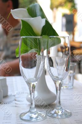 Empty champagne glasses and calla lily flower