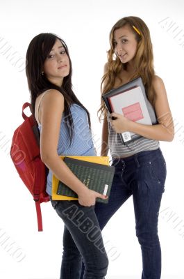 school girls standing together holding books