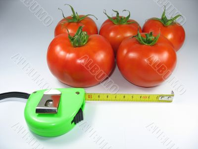 Fresh red tomatoes and an green measuring tape