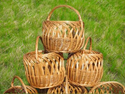 three wicker wooden baskets over green grass background