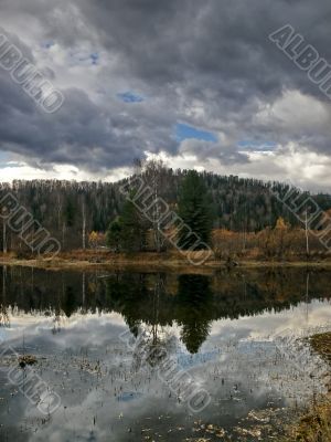 Heavy sky reflexion in dark lake