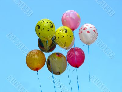 Bunch of colored party balloons against blue sky