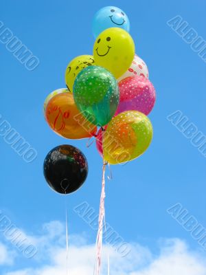 Bunch of colored party balloons against blue sky