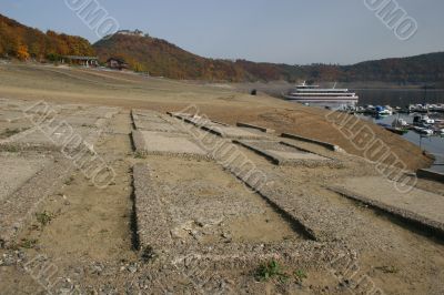 Empty reservoir Edersee with lost cementary