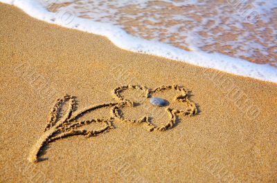 `Flower` drawing at sand, with sea wave