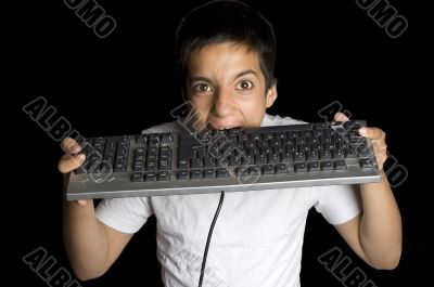 frustrated teenage boy is biting on his keyboard isolated on bla