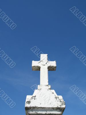 a stone cross and blue clear sky