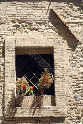 Bevagna, Window with red flowers and tie-beam