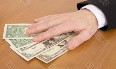 Man`s hand over dollars
