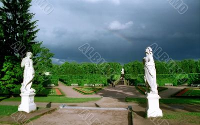Classical statues in park and rainbow