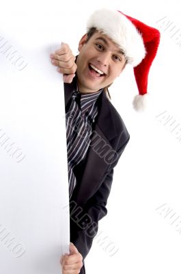 executive in christmas hat peeping through placard