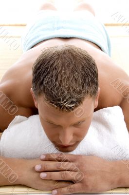 young male lying on mat ready to take spa