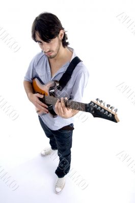 handsome male looking at camera and playing guitar