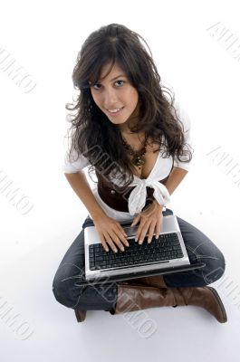 female operating laptop and looking at camera