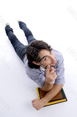 young fellow lying on floor with his books