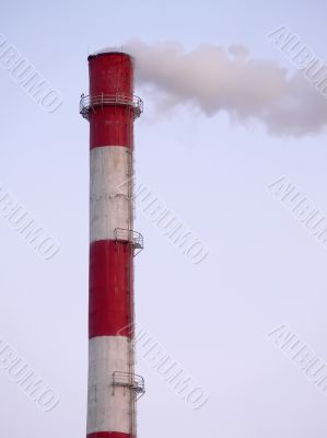 Smoking factory pipe in sunset