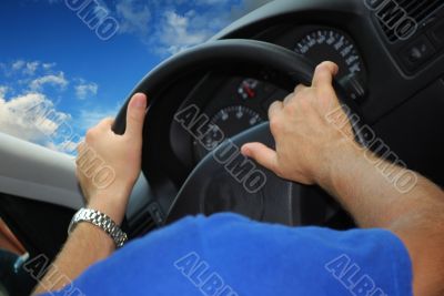 Male hands on a rudder of the car