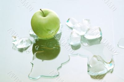 green apple and melting ice blocks on the mirror