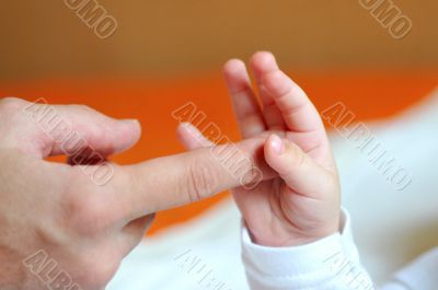 Children`s pen in the hands of adult fingers