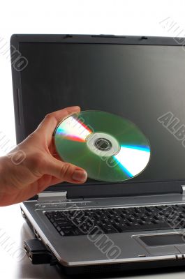 Close up. Woman with cd disk in a hand used notebook