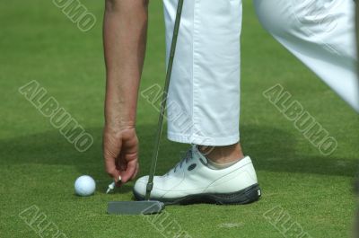 golfer placing golf ball on a tee