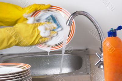 Man hands in, washing the dishes at the kitchen