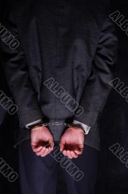 Arrested businessman handcuffed hands at the back