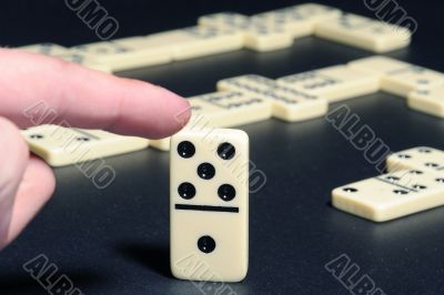 Human fingers push a dominoes. Human fingers push a dominoes.