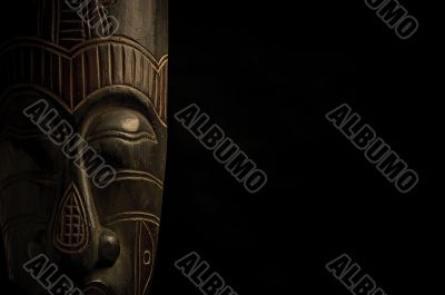 African mask over black background