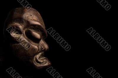 African mask over black background