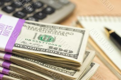 Stack of Money, Calculator, Paper and Pen Stack of Money, Calculator, Paper and Pen