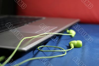Green earphones and laptop