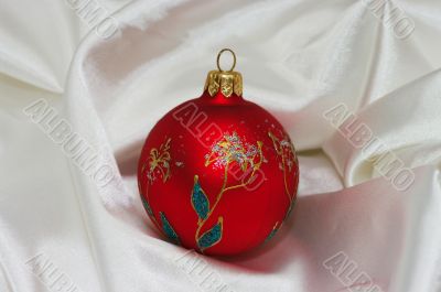 red christmas ball on soft white fabric with copy space