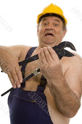 Plumber with pipe wrench and safety helmet