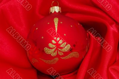 red christmas ball on soft red fabric with copy space