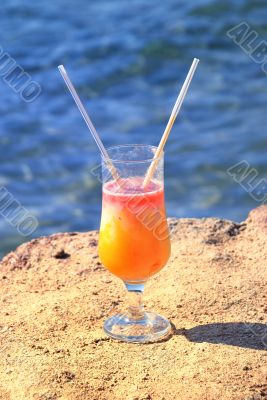 fresh juice orange and papaya on the beach of the sea