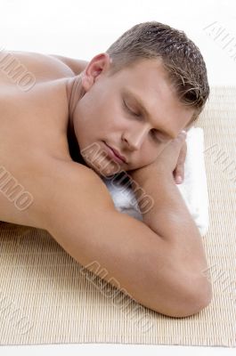 male lying on mat ready to take spa treatment